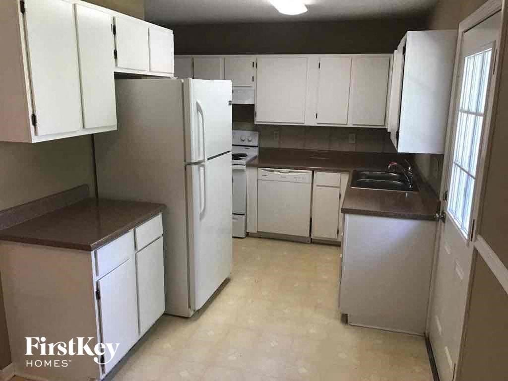 A kitchen with white cabinets and appliances.