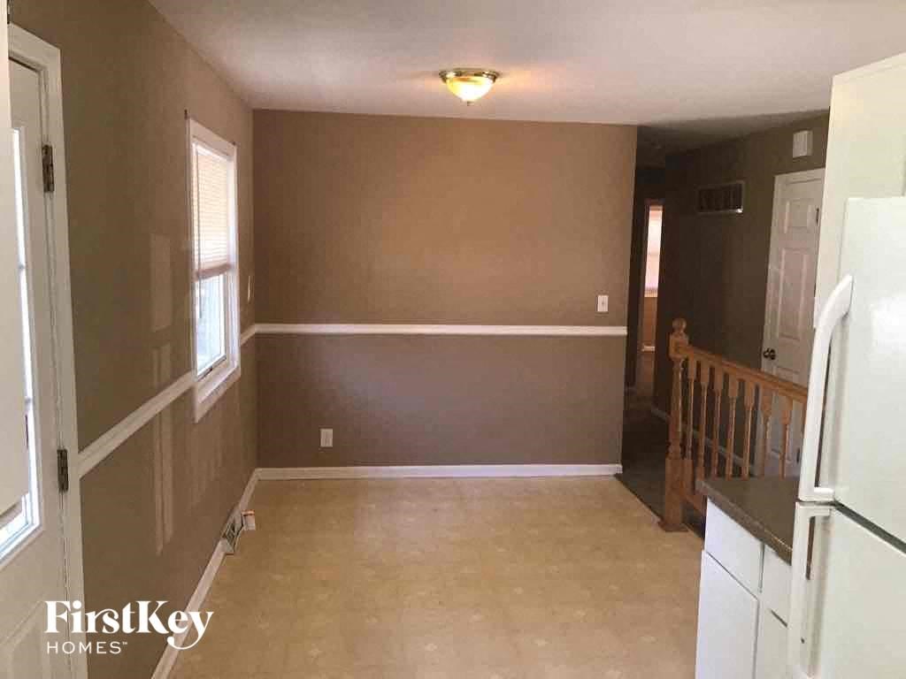 A kitchen with a refrigerator, cabinets, and a counter.