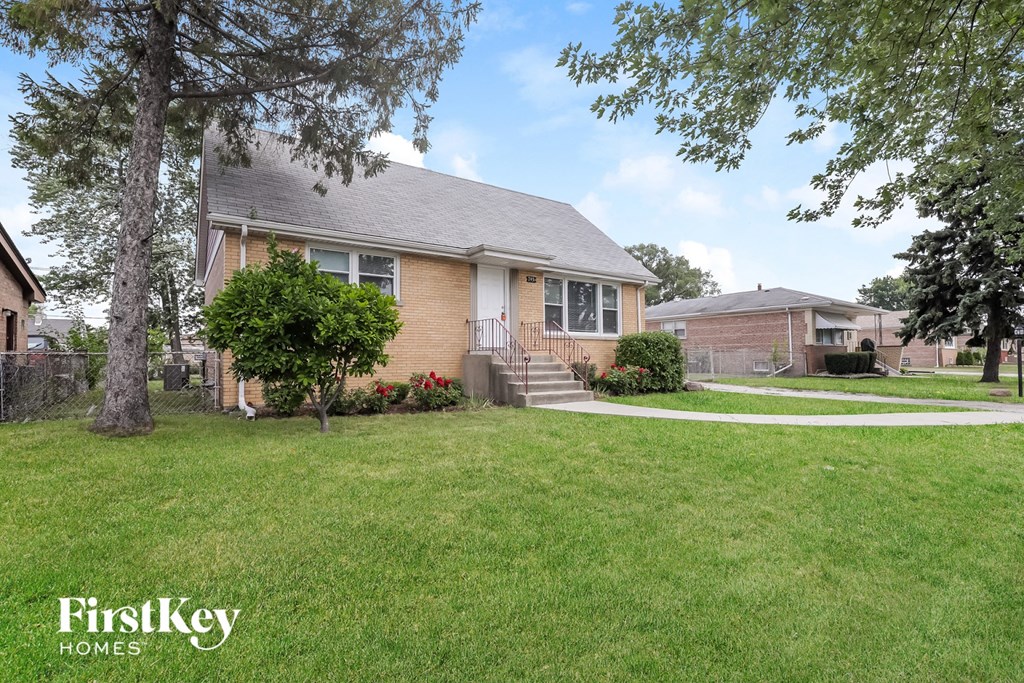 a home with a lawn and a sidewalk in front of it