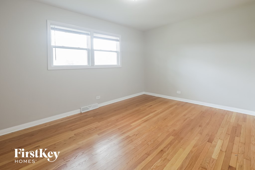 an empty room with wood floors and a window