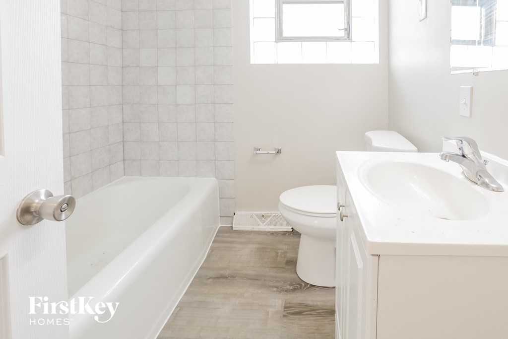 a white bathroom with a toilet sink and tub