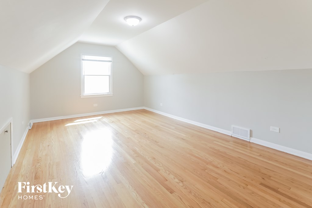 the living room of a home with wood floors and white walls