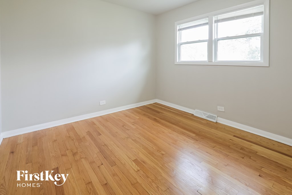 an empty room with wood floors and a window