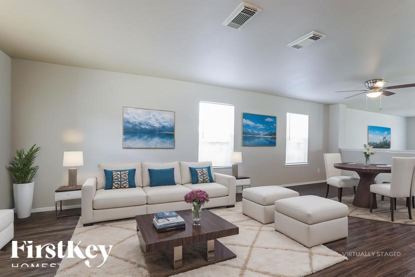 A living room with a white couch, a coffee table, and a painting on the wall.