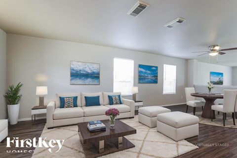A living room with a white couch, a coffee table, and a painting on the wall.
