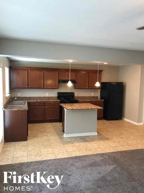 A kitchen with wooden cabinets and black appliances.