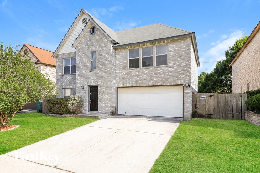 A house with a garage and a driveway in front.
