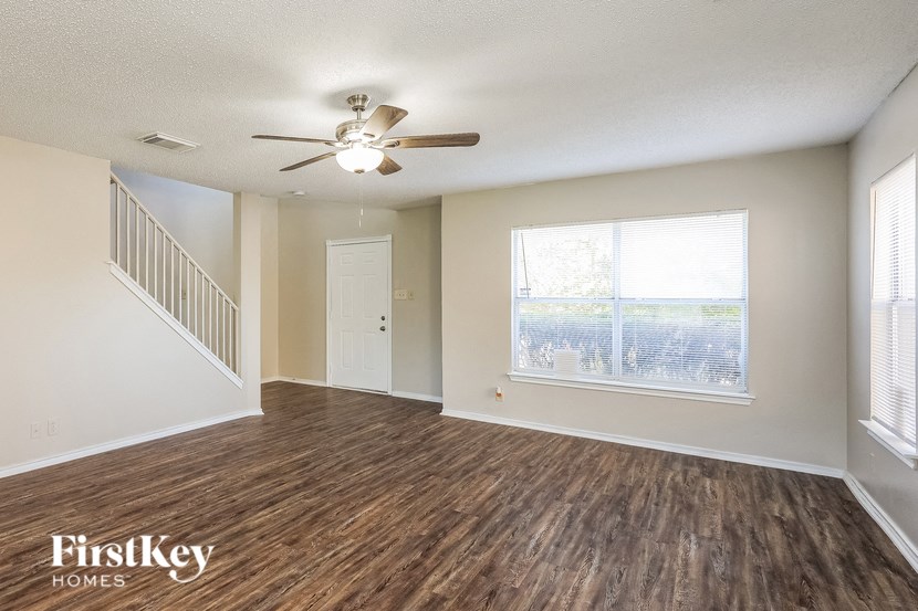 A room with wooden floors and a ceiling fan.
