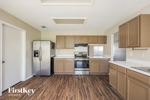 A kitchen with wooden floors and a refrigerator.