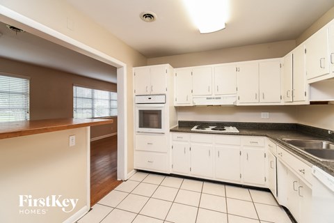 A kitchen with white cabinets and appliances.