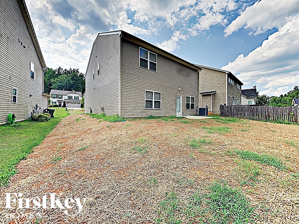A large grassy yard in front of a two story house.