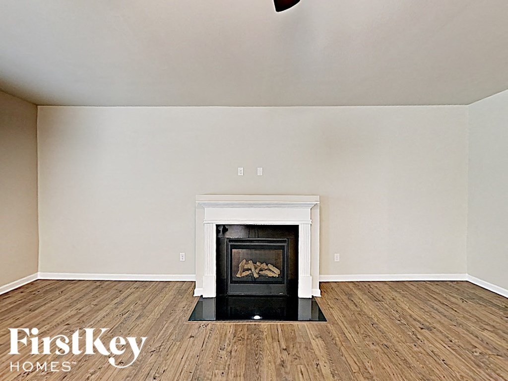 A room with a fireplace and wooden floors.