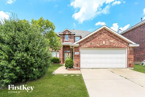 a brick house with a white garage door in front of it