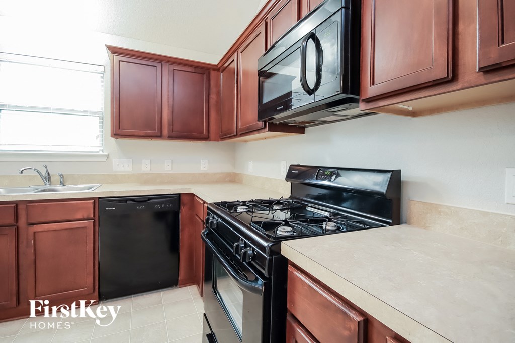 a kitchen with a stove and a microwave and a sink