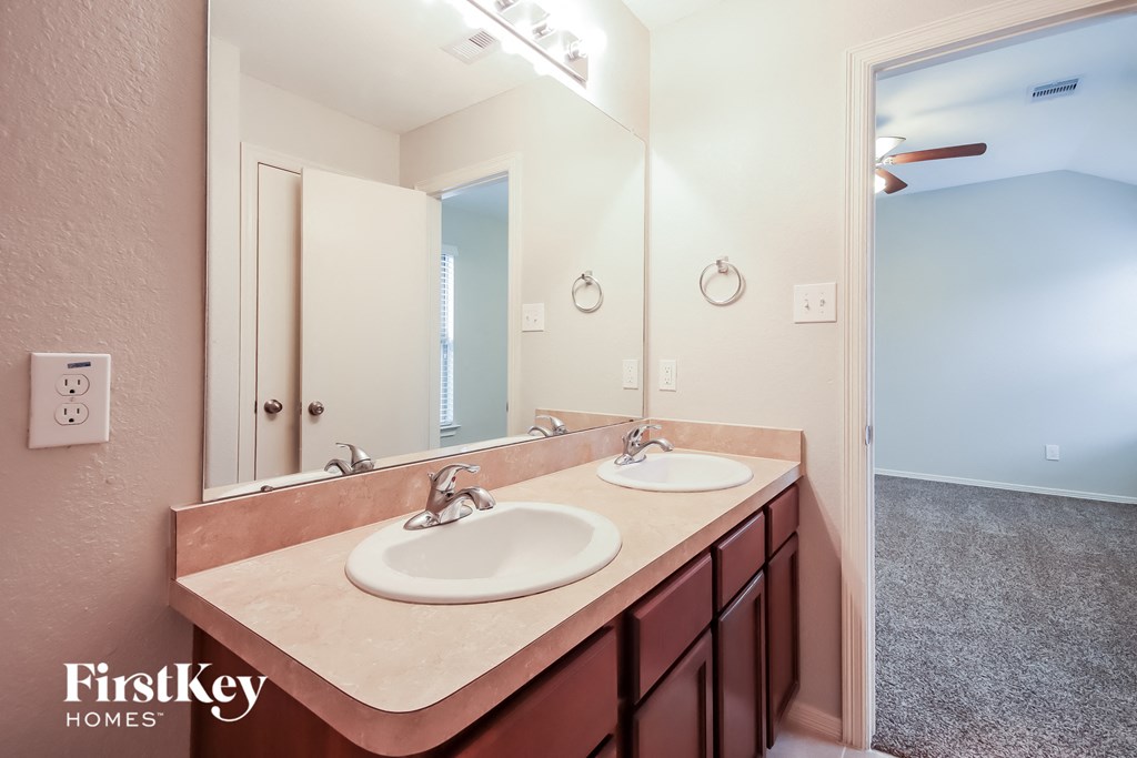 a bathroom with two sinks and a large mirror
