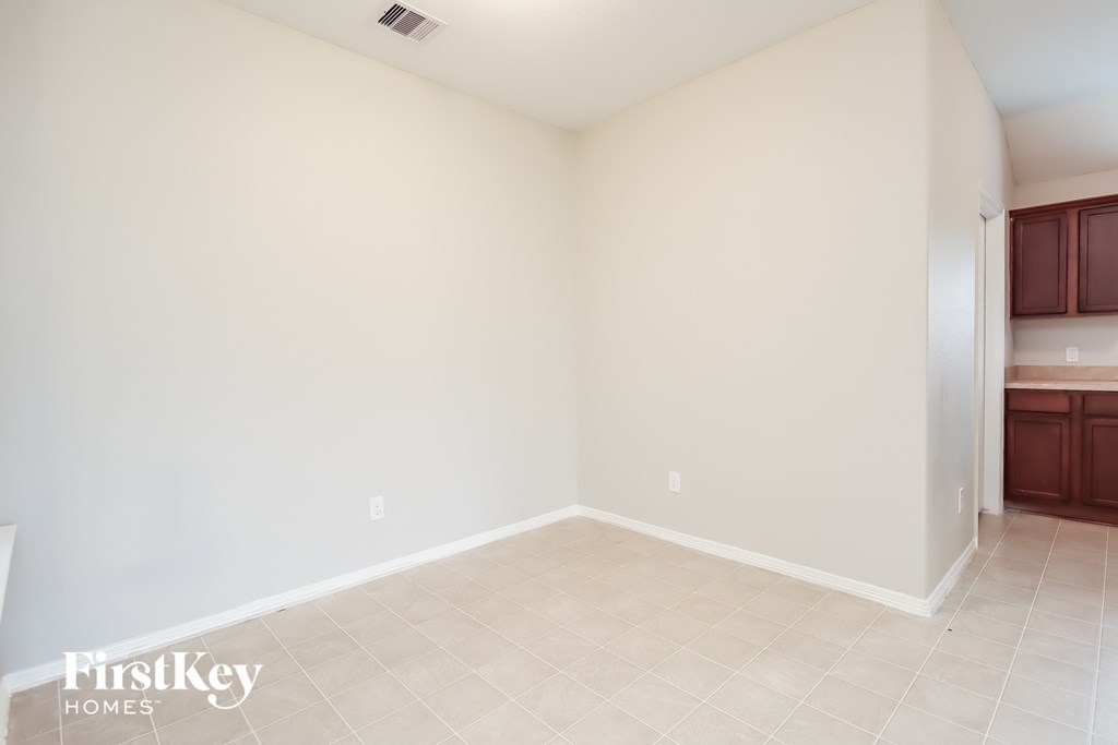 an empty living room with white walls and tile floor