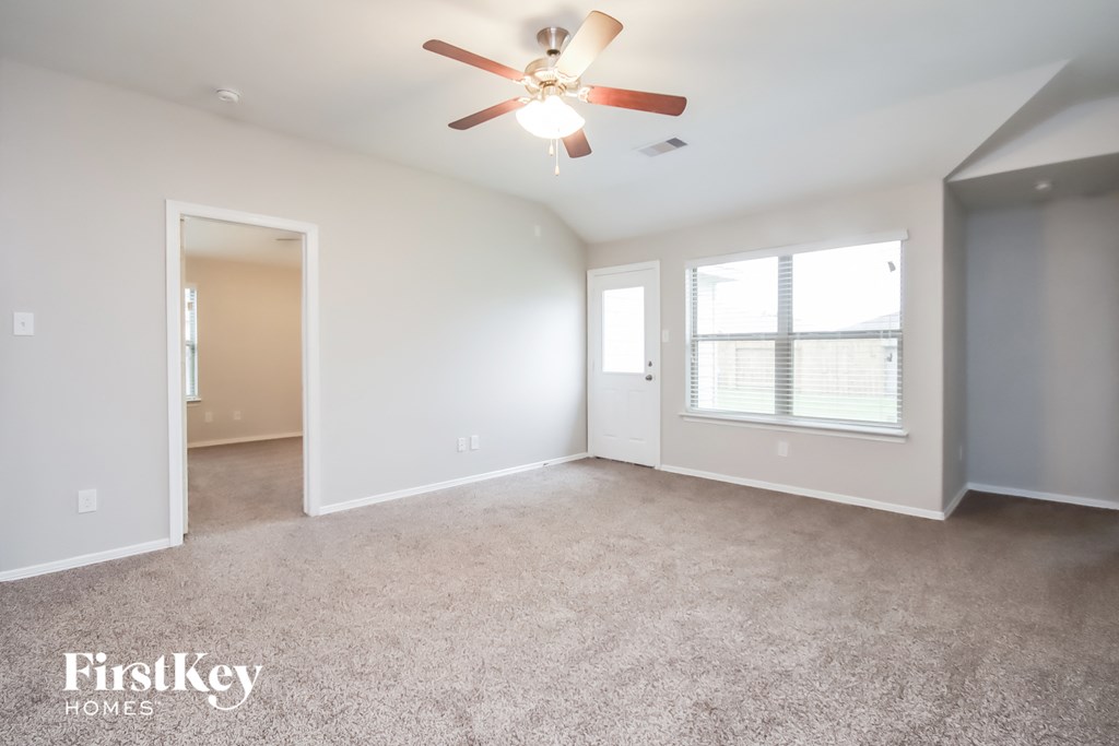 a living room with carpet and a ceiling fan