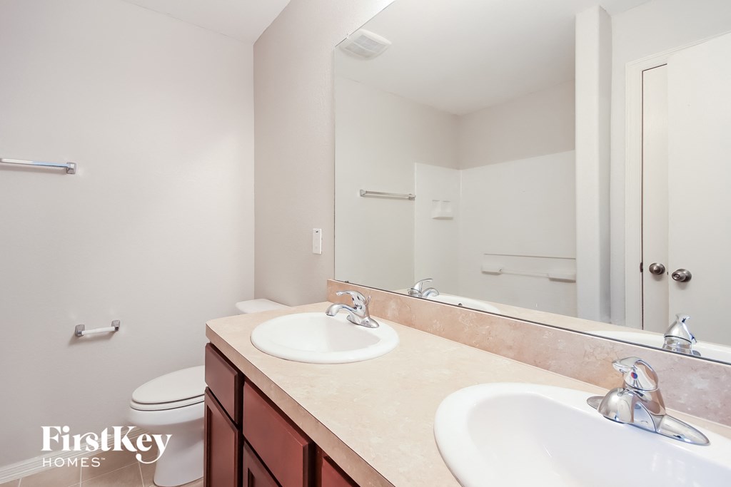 a bathroom with two sinks and a mirror and a toilet