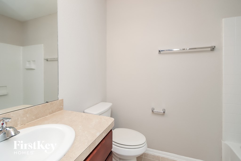 a bathroom with a sink toilet and a mirror