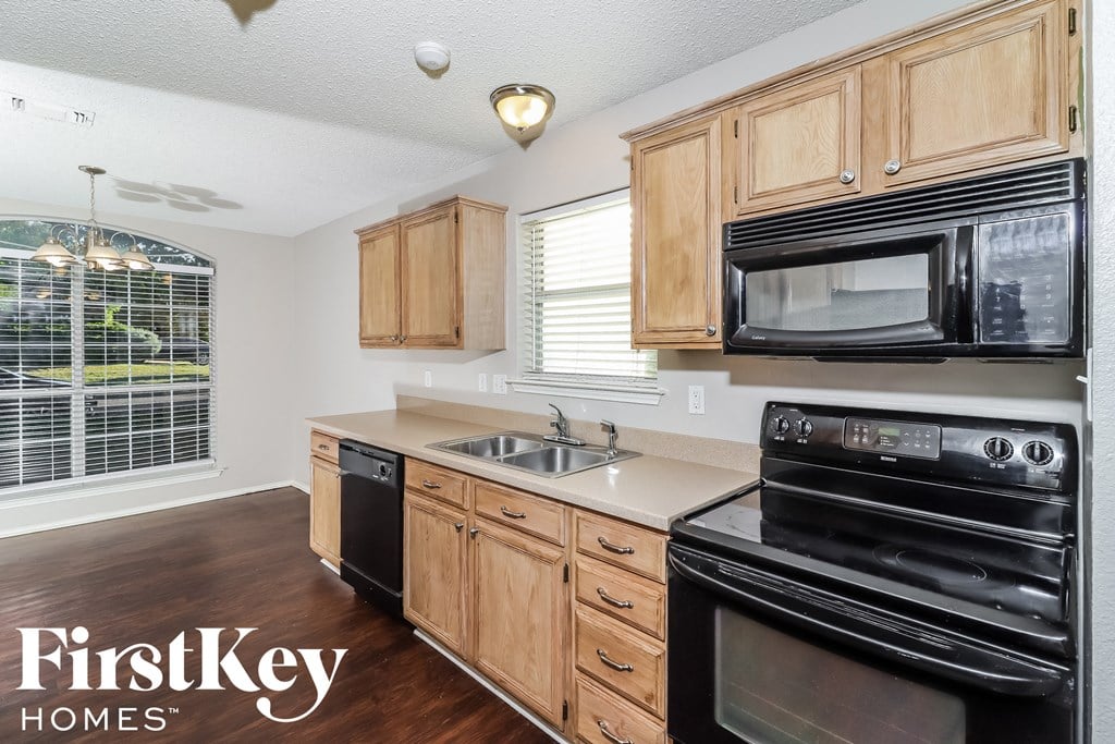 A kitchen with wooden cabinets and black appliances.