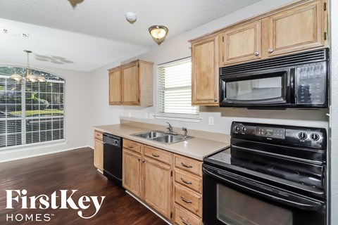 A kitchen with wooden cabinets and black appliances.
