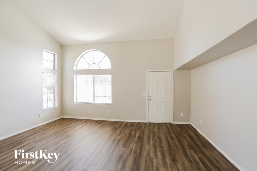 an empty living room with white walls and wood flooring