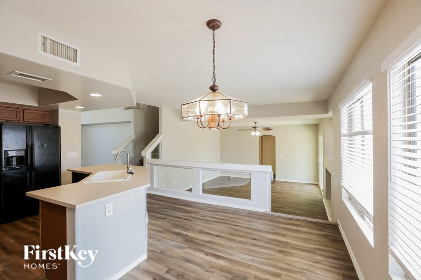 a kitchen and living room with a white counter and a chandelier