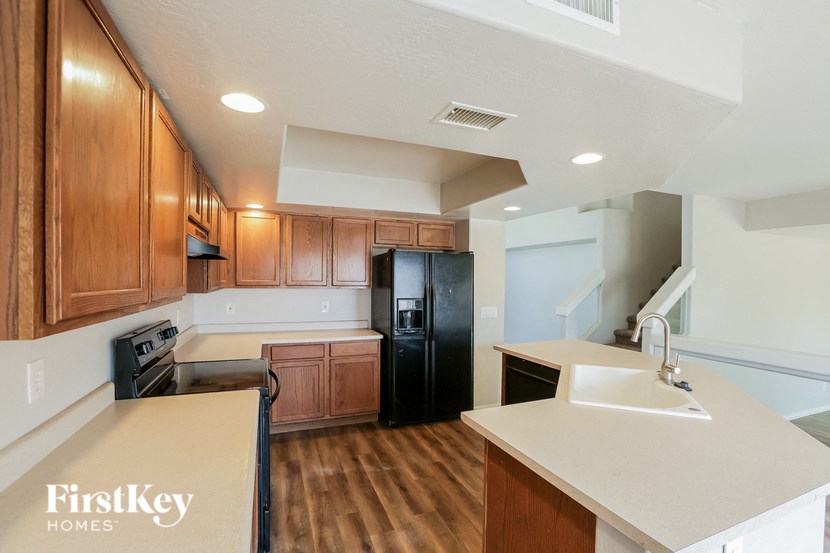 a kitchen with wooden cabinets and a black refrigerator