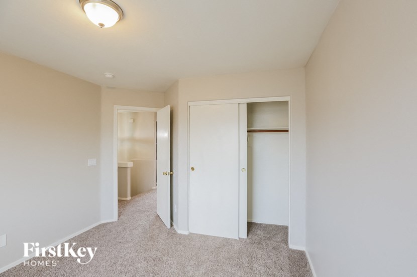 a bedroom with a closet and a toilet and a mirror