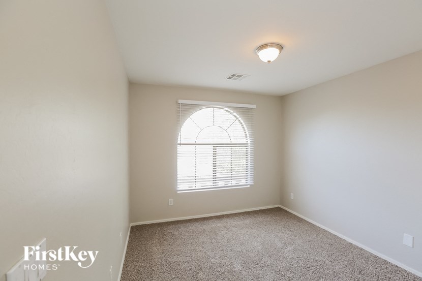a bedroom with a large window and a carpeted floor