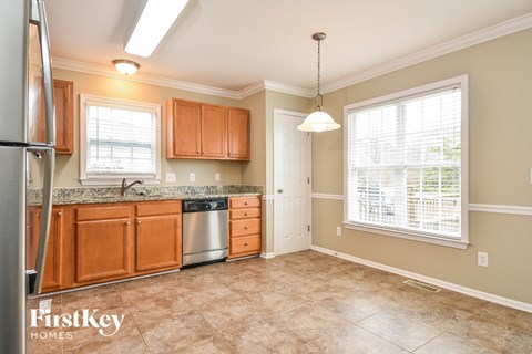 A kitchen with wooden cabinets and a stainless steel dishwasher.