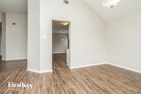 the living room and dining room of an apartment with wood flooring