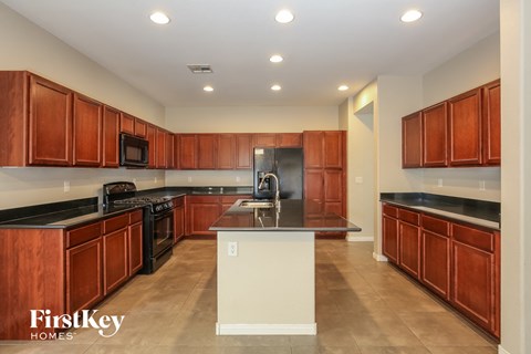 a kitchen with wooden cabinets and black counter tops and a sink