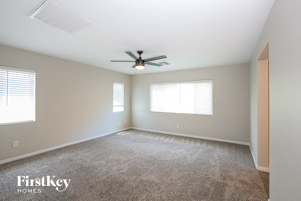 an empty room with a ceiling fan and a window