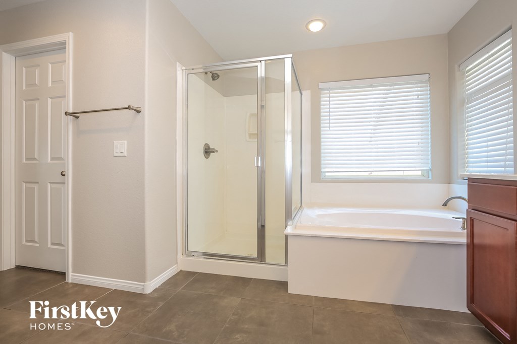 a bathroom with a tub and a shower and a sink