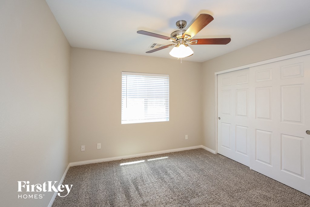 a bedroom with a ceiling fan and a white door