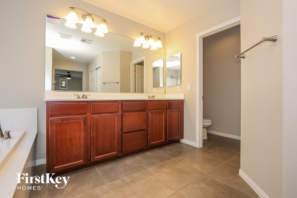 the master bathroom has a large vanity and a large mirror