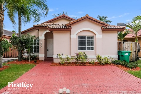 a house with a driveway and palm trees