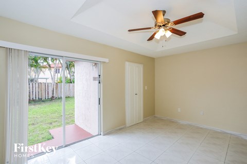 a living room with a sliding glass door and a ceiling fan
