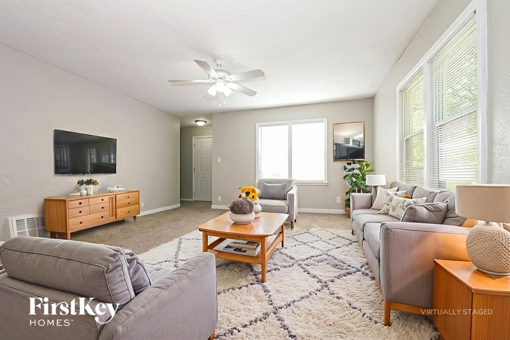A living room with a grey couch and a wooden coffee table.