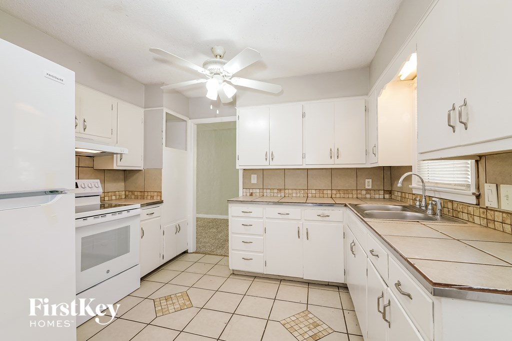 A kitchen with white appliances and cabinets.