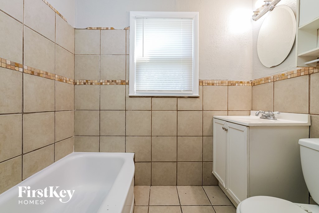 A bathroom with a white tub, toilet, and sink.