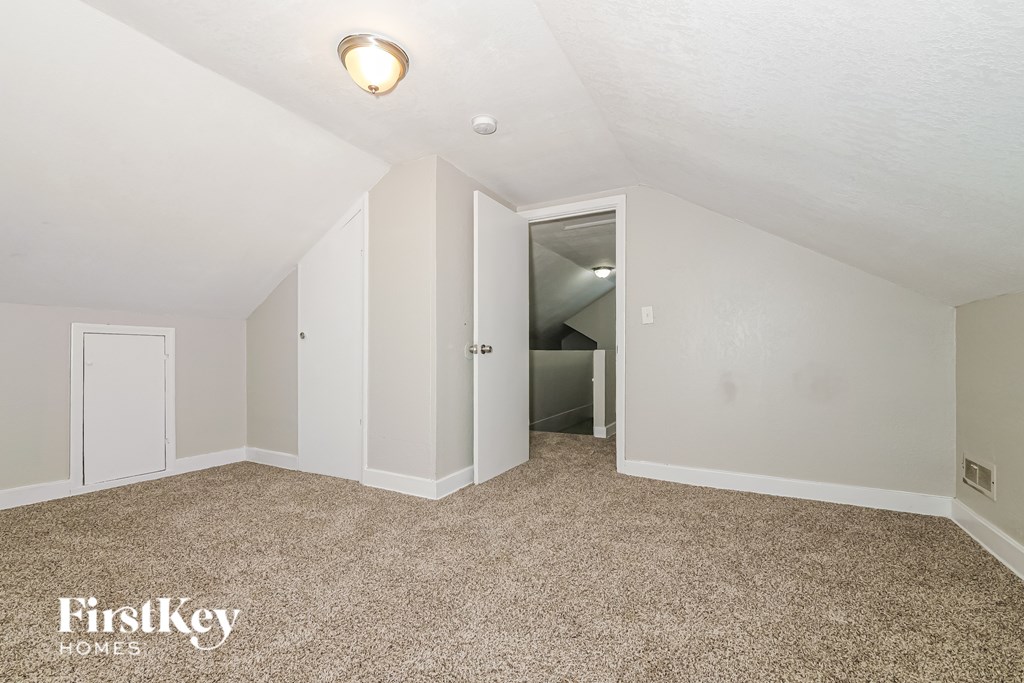 A carpeted room with a FirstKey HOMES logo.
