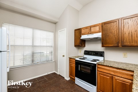A kitchen with wooden cabinets and a stove top oven.