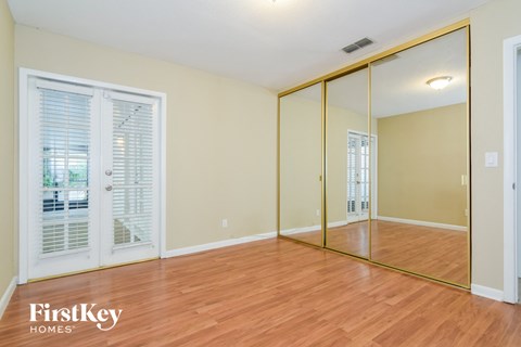 a living room with a wood floor and mirrors on the wall