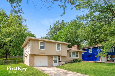 a beige house with a blue house behind it