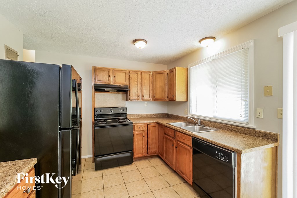 a kitchen with black appliances and wooden cabinets