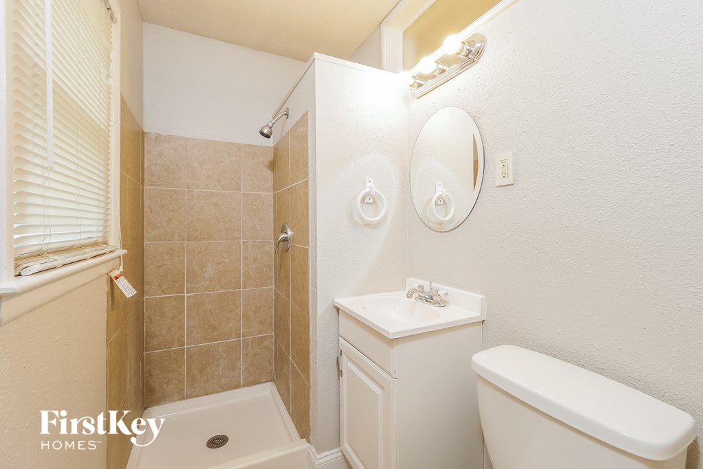 a bathroom with a toilet and a sink and a shower