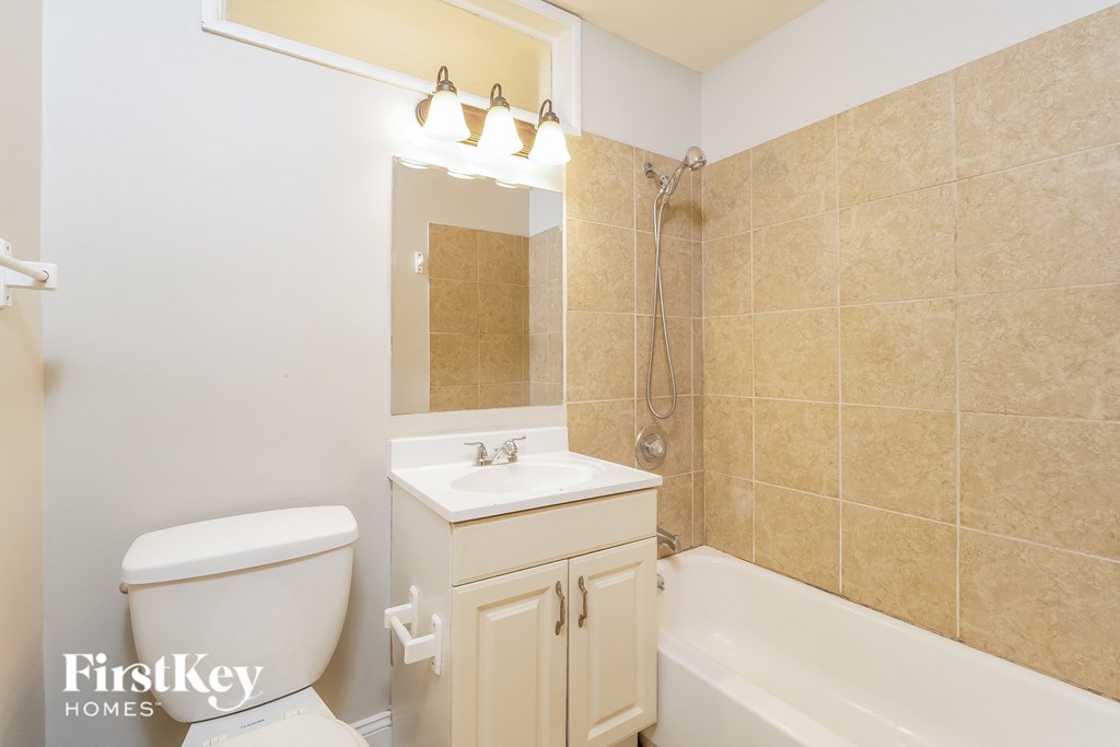 a bathroom with a toilet sink and tub and a mirror