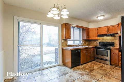 A kitchen with brown cabinets and a black stove top oven.